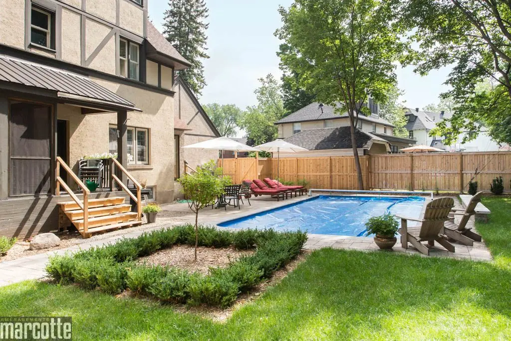 Paysagement d’une cour autour d’une piscine avec dalles et végétaux