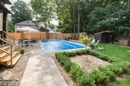 Paysagement d’une cour autour d’une piscine avec dalles et végétaux