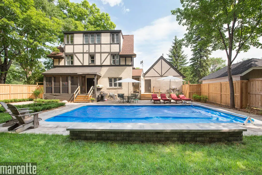 Paysagement d’une cour autour d’une piscine avec dalles et végétaux