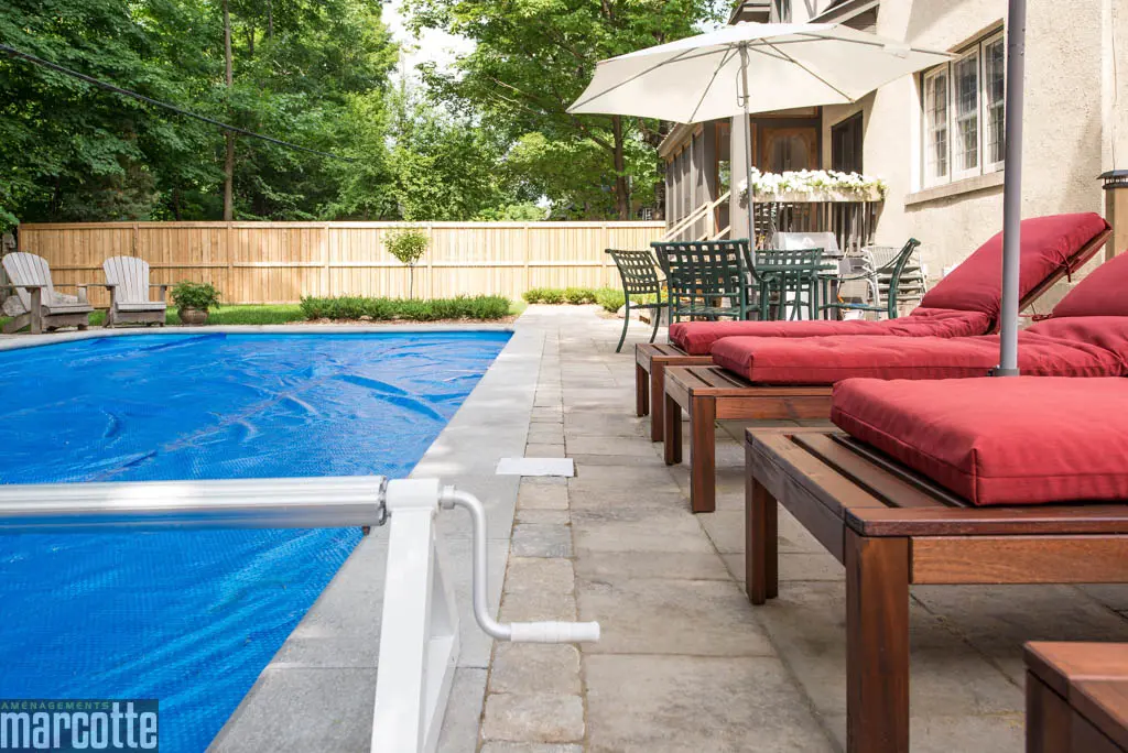 Paysagement d’une cour autour d’une piscine avec dalles et végétaux