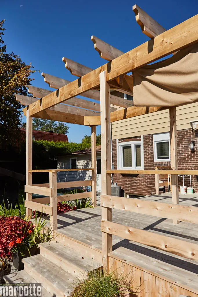 Terrasse en pierre adjacente à un deck en bois assortie d’une pergola